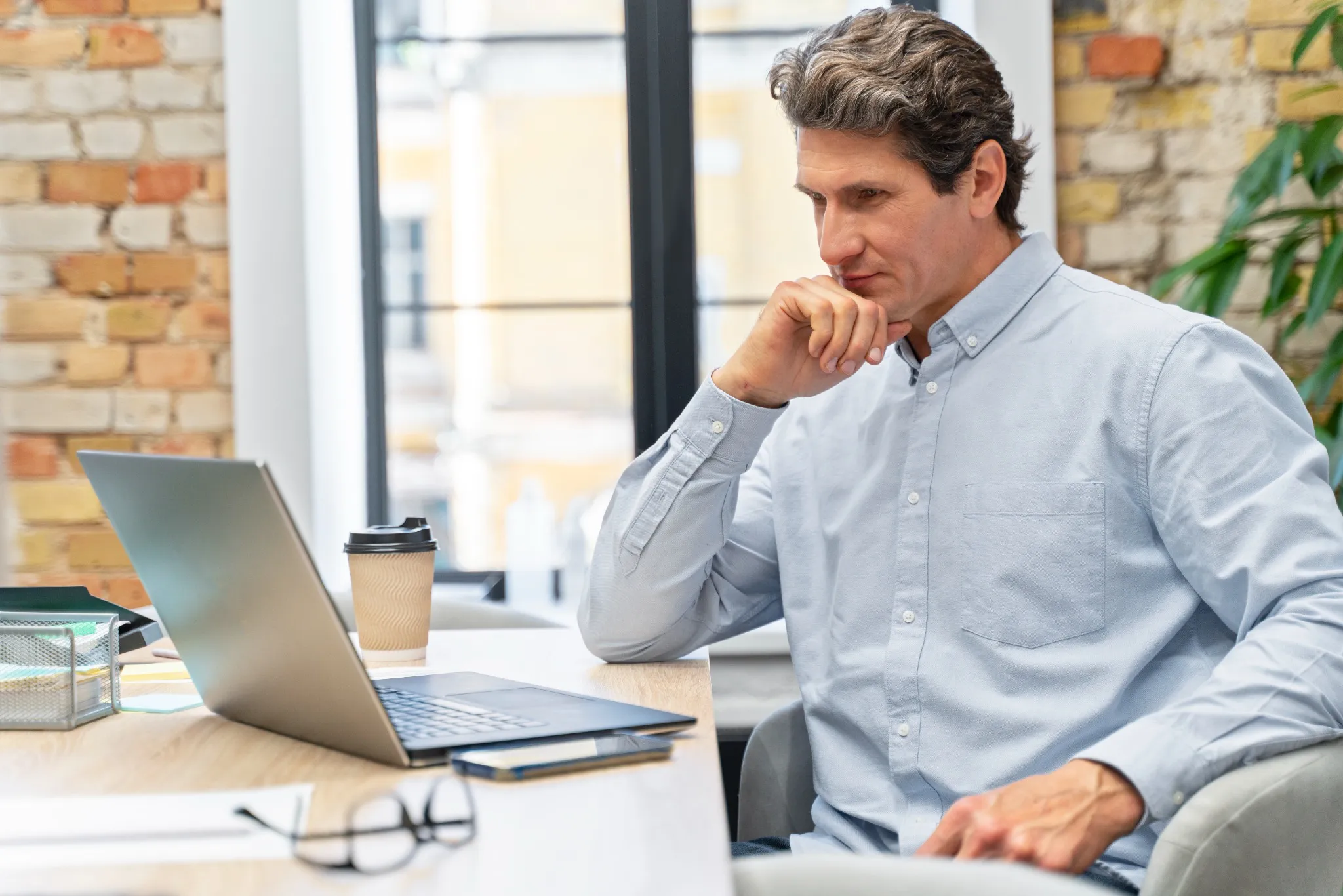 Homme devant ordinateur cherche solution pour avoir des liens